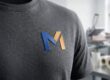 Detailný záber na kvalitné tmavosivé firemné tričko s modernou 3D potlačou loga vyrobenou technológiou DTF v reklamnej agentúre v Michalovciach.